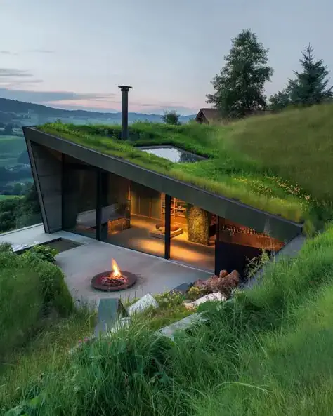 Real estate investment projects in Tbilisi, Georgia: Modern hillside house with green roof and panoramic glass wall – eco-friendly investment home concept by LD Estates