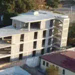 Real estate investment projects in Tbilisi: Close-up of multi-level investment building under construction in Avlabari, Tbilisi with rooftop view and structural framework