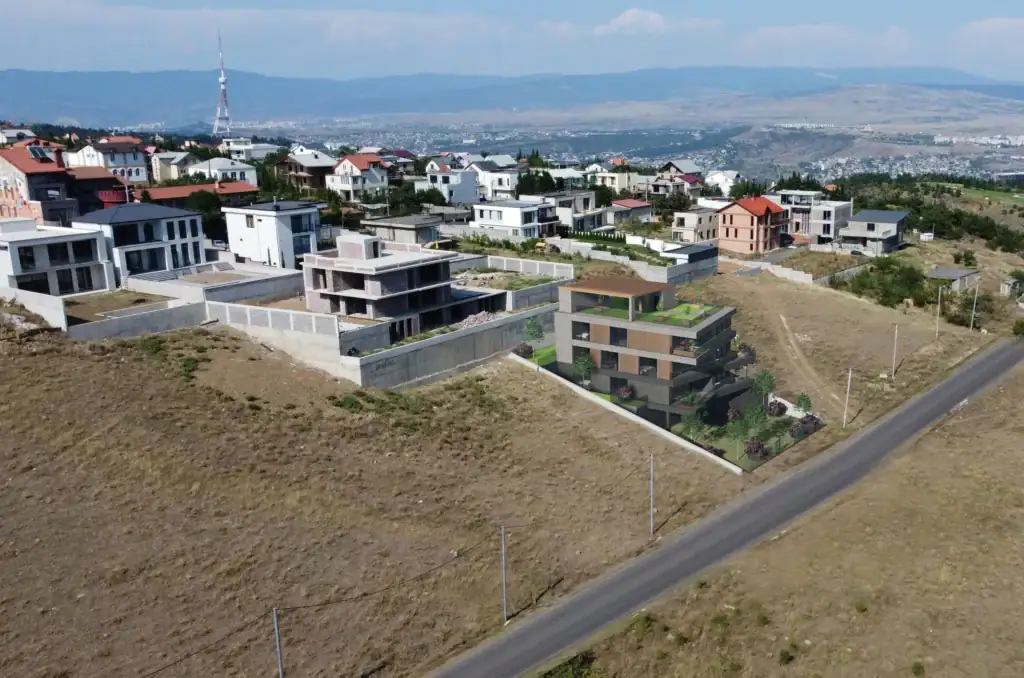 Tbilisi investment land with apartments project: Photorealistic render of modern apartment building integrated into Tabor Hill drone image – LD Estates investment real estate in Tbilisi