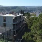 Real estate investment building in Tbilisi: Drone view of Avlabari real estate Real estate investment projects in Tbilisi - Avlabari office building under construction / LD Estates mid-rise building with city and mountain backdrop