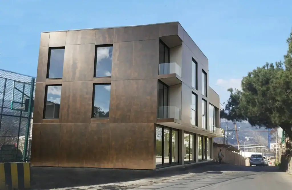 Tbilisi Real Estate Project Update – Avlabari Hill investment building with bronze Laminam metallic facade, street view.