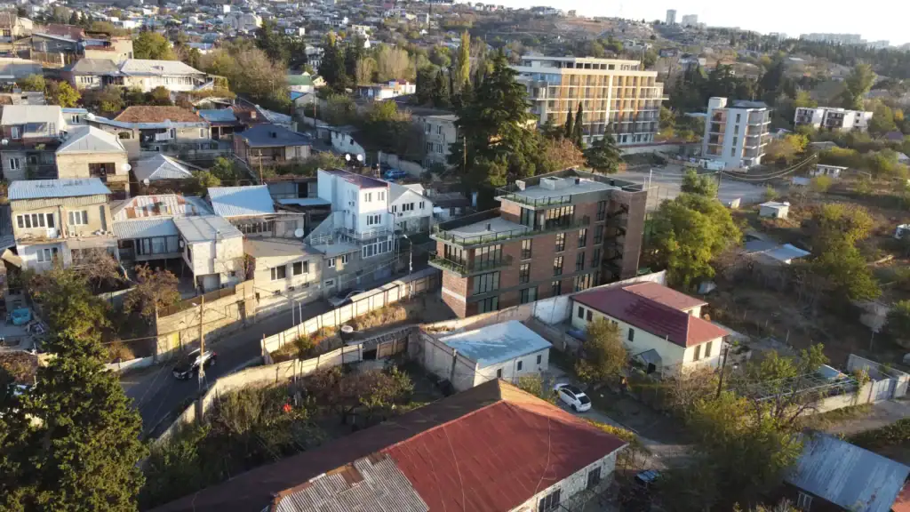 Avlabari Hill investment property in Tbilisi with a modern red brick facade – aerial perspective.