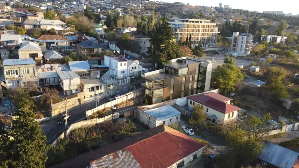 Tbilisi Real Estate Project Update – Avlabari Hill investment property with Laminam bronze metallic facade, aerial angle view.
