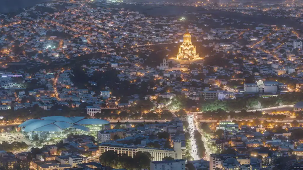 Invest in Georgia real estate – panoramic night view of Tbilisi with Sameba Cathedral and city lights