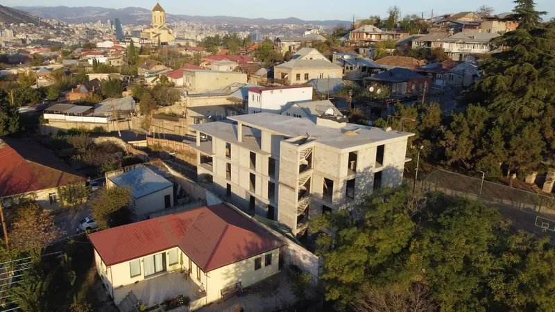 Current black-frame concrete shell of the Avlabari building seen from above, showing the existing structure and its flat roof