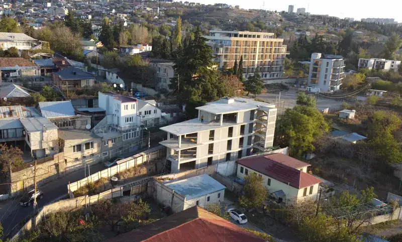 Aerial view of the Avlabari building showing its flat roof slab and the surrounding neighborhood with a mix of residential buildings
