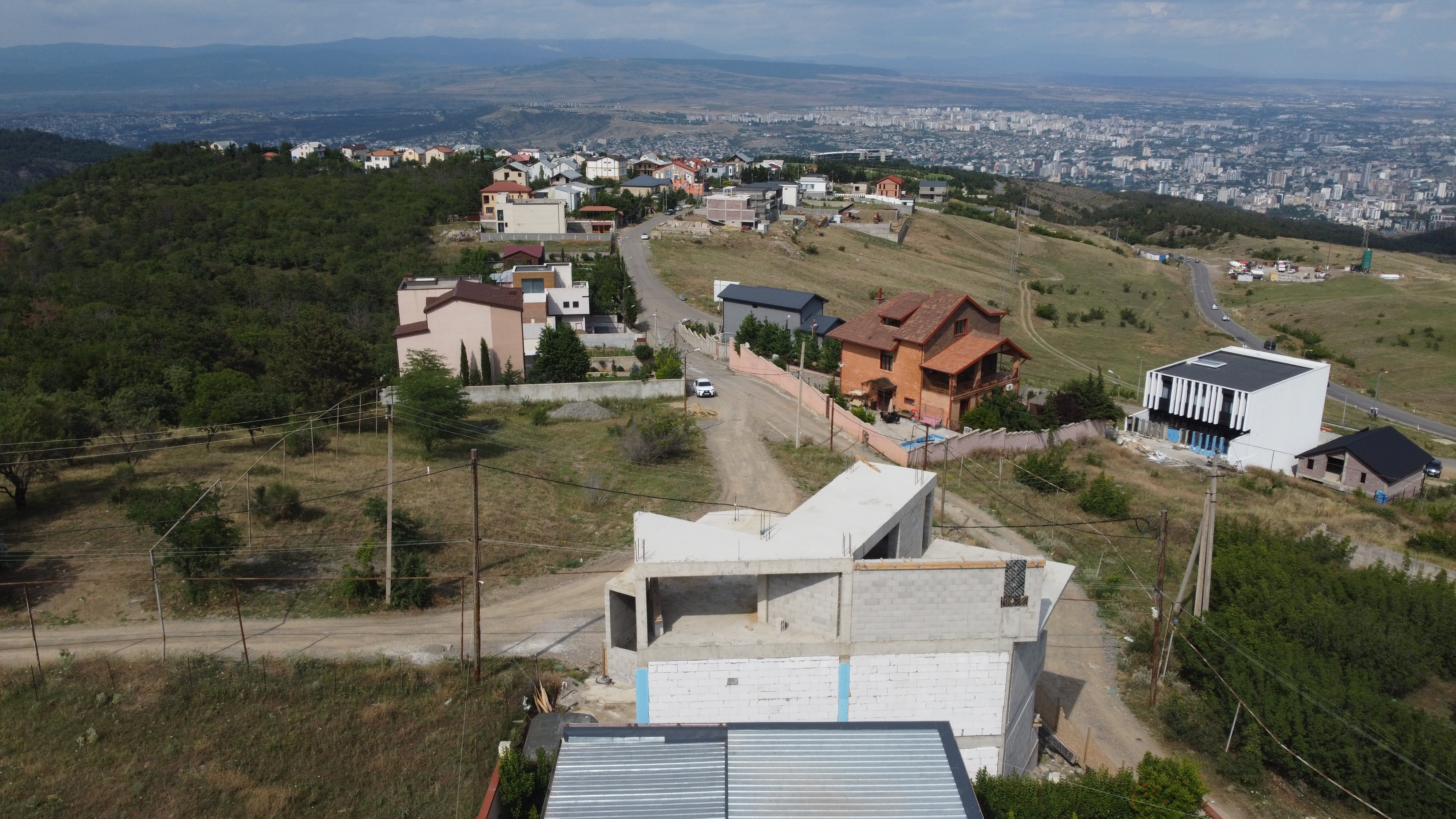 Aerial site context view showing 201 m² hillside plot in Tabor Hill, access road, and surrounding residential neighborhood